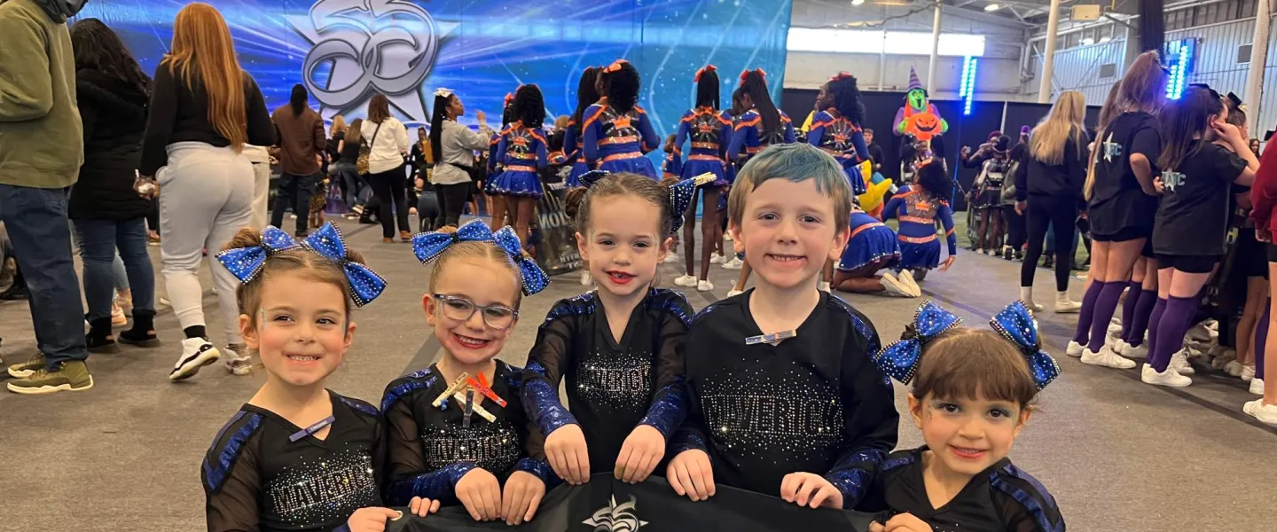 Group of 5 cheer leaders holding up their competition flag in excitement