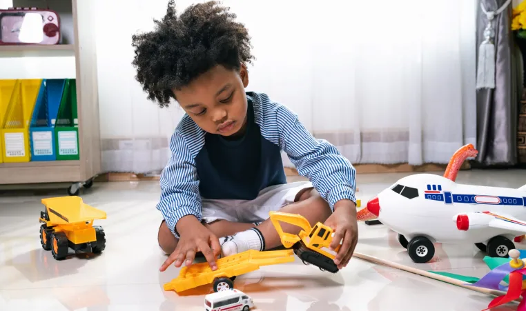 Happy black people African American child play truck and airplane toy