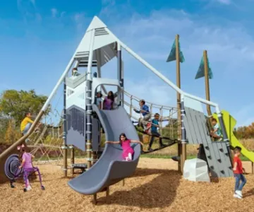Kids playing on giant playground mock up with slides, towers, climbing wall, and more