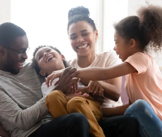 Overjoyed biracial family with kids have fun at home