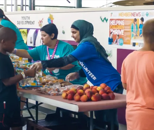 Line of kids waiting for a healthy meal with the help of volunteers