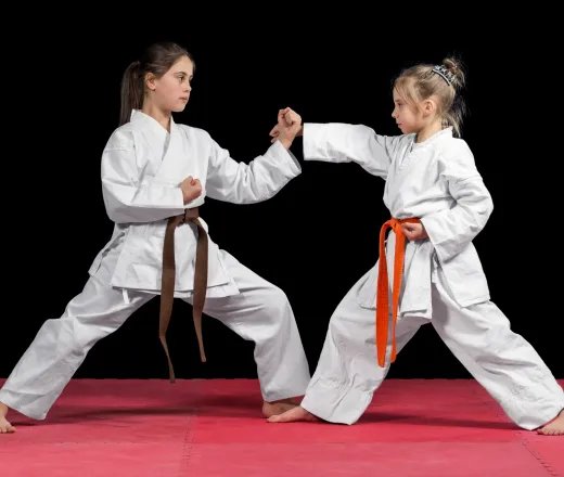 Two girls in kimono are training paired exercises karate